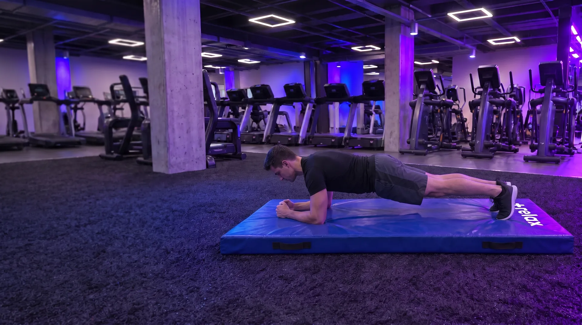 Persona haciendo plancha sobre una colchoneta de gimnasio +relax